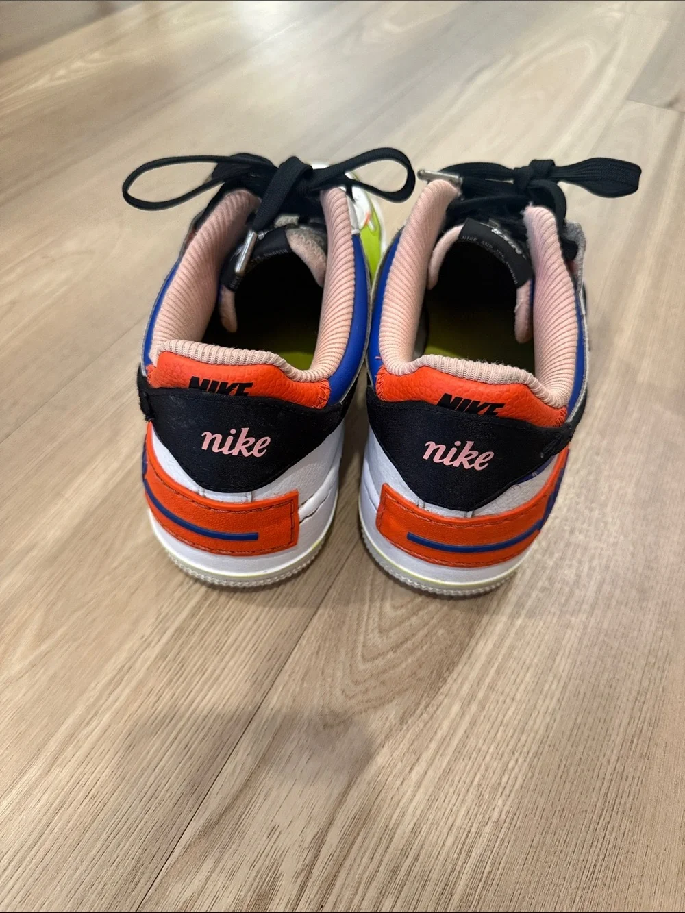Nike White Low-Top Sneakers with Black Swoosh and Neon Green & Orange Accents